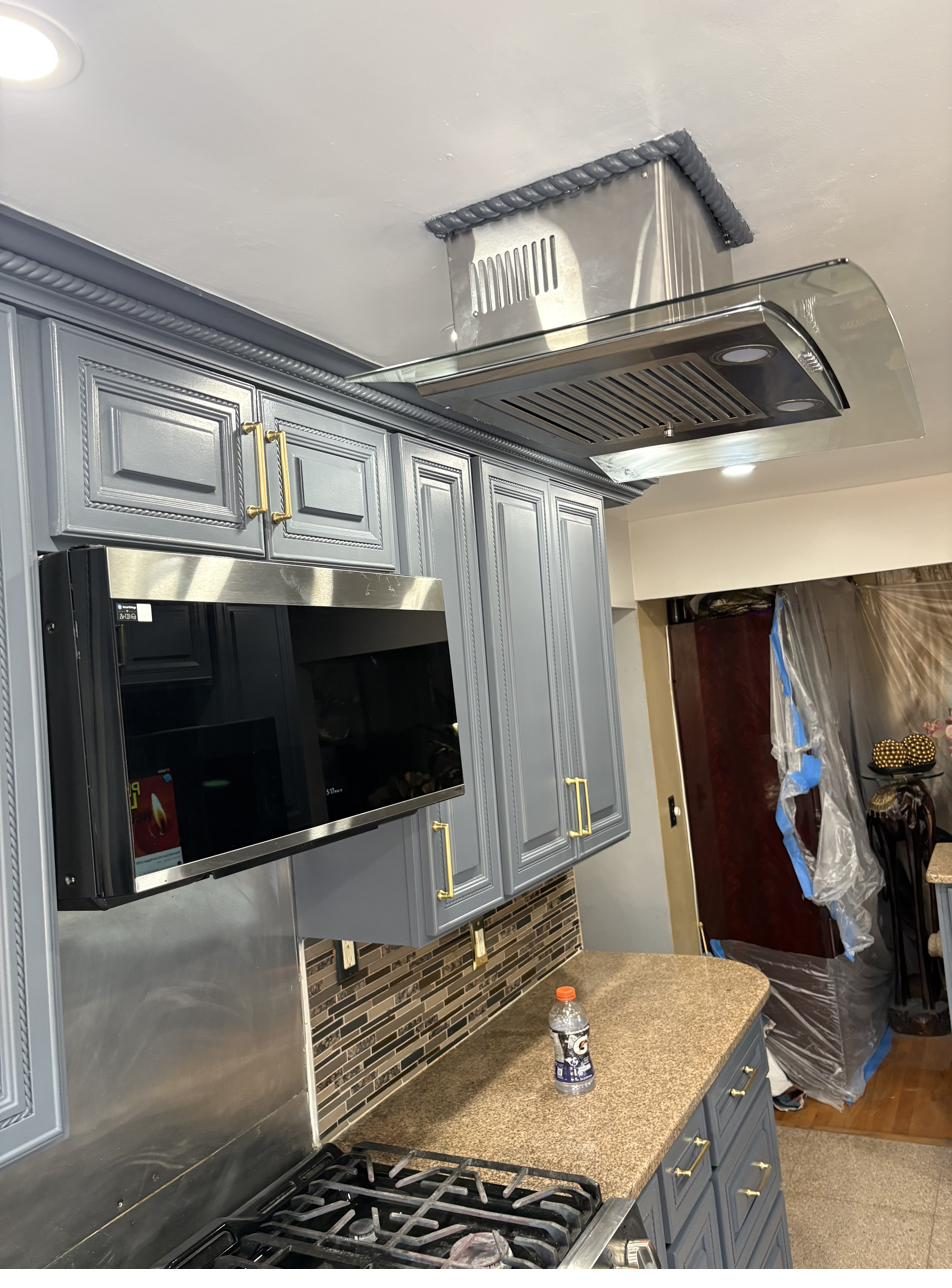 Modern glass range hood with painted cabinetry